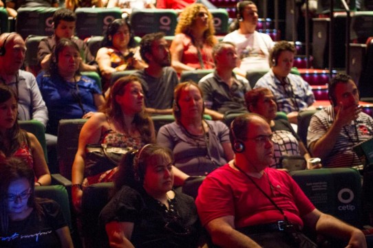 Descrição: Fotografia colorida de várias pessoas com e sem deficiência visual sentadas na plateia do Teatro Cetip assistindo ao musical BEATLES NUM CÉU DE DIAMANTES com audiodescrição. Na primeira fileira, da esquerda para direita, Malu Brancia, Luciana e Fábio Bittar; na segunda fileira, Verônica Guimarães, Lilian Alves e sua mãe Aparecida Pontin, Alexandre Costa; na terceira fileira, Marco Antônio Bertolli e Kátia Chimabokuro, Edgard Jacques e seu pai; na quarta, Diniz Cândido e Margarida, Ana e André Poeta.