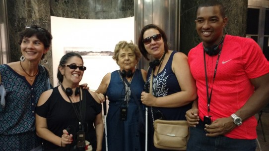 Fotografia colorida de Mônica Martins com Regininha Fumiê, Gilda Torralbo e Edna com o atleta paralímpico Ricardo Costa, no hall da Caixa Cultural, aguardando para assistir ao espetáculo Poema Suspenso para uma Cidade em Queda. 